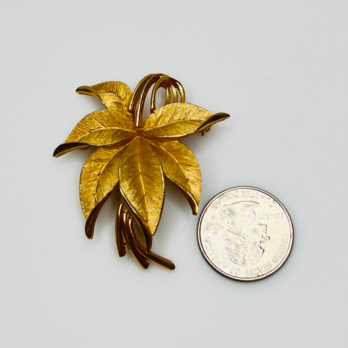 Crown Trifari brushed gold-tone leaf brooch with curling ribbon detail