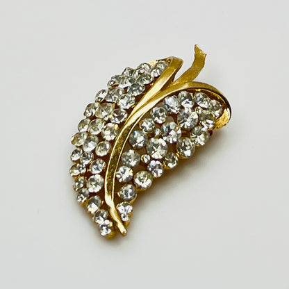 Close-up of Trifari brooch with clear rhinestones in leaf motif
