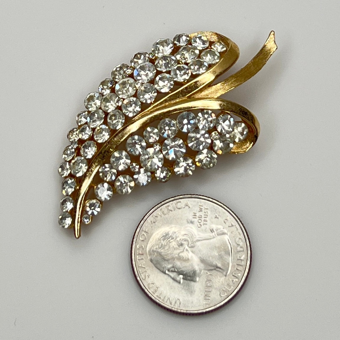 Close-up of Trifari brooch with clear rhinestones in leaf motif