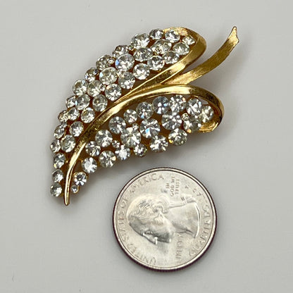 Close-up of Trifari brooch with clear rhinestones in leaf motif