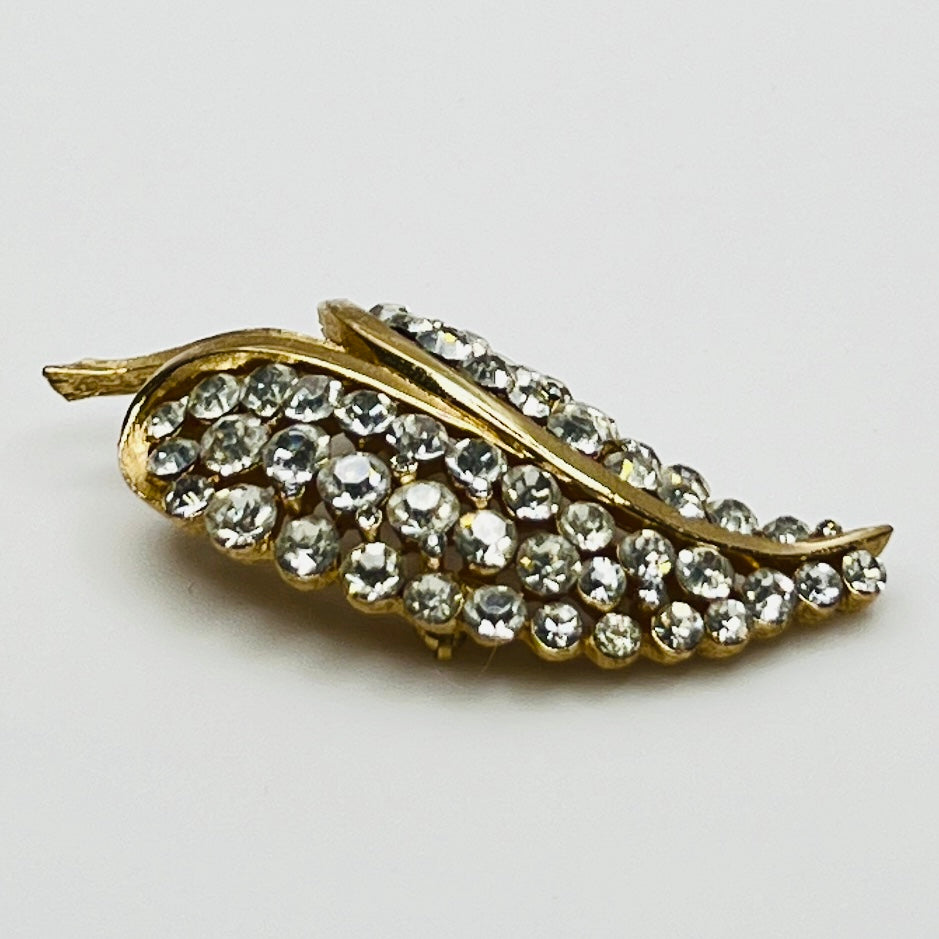 Close-up of Trifari brooch with clear rhinestones in leaf motif