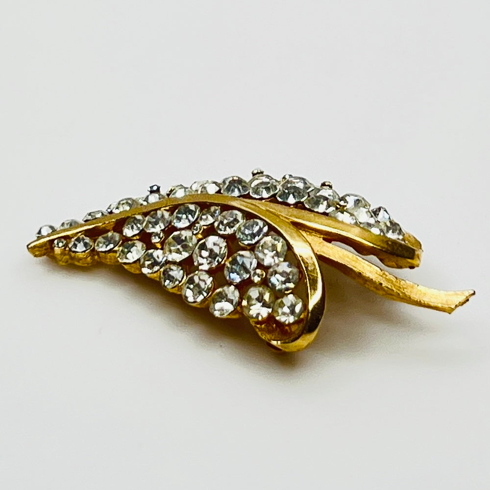 Close-up of Trifari brooch with clear rhinestones in leaf motif