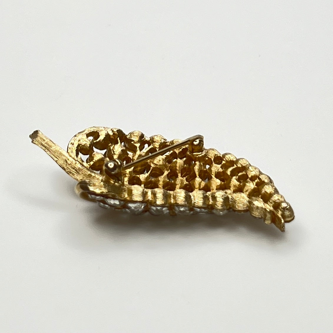 Close-up of Trifari brooch with clear rhinestones in leaf motif