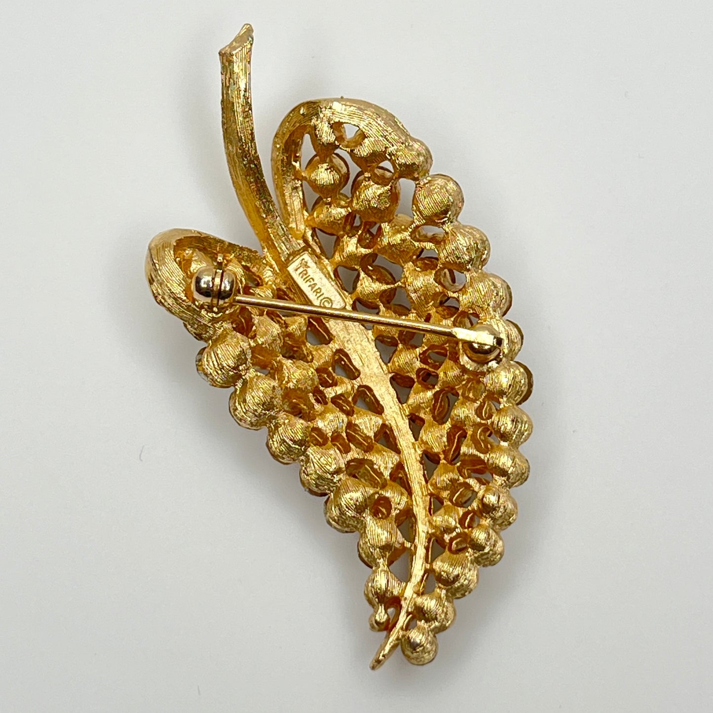Close-up of Trifari brooch with clear rhinestones in leaf motif