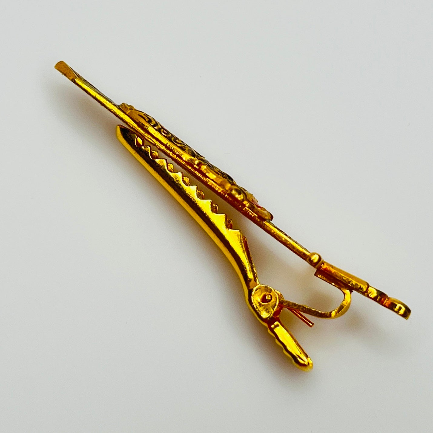 Close-up angled view of Spanish-style vintage tie bar with sword shape