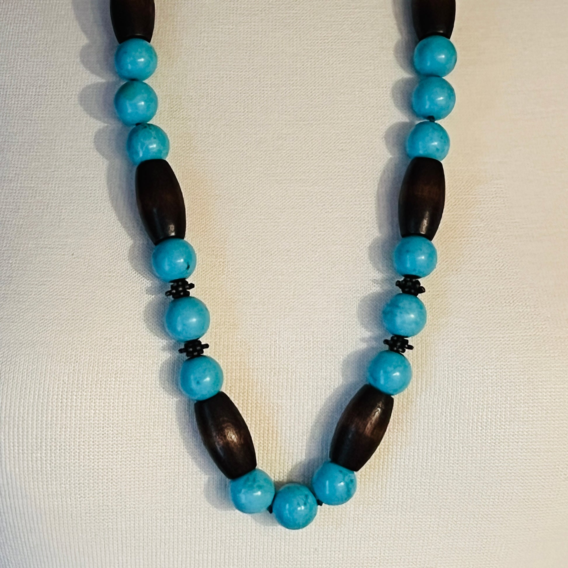 EXEX sterling silver and turquoise necklace with wood beads displayed on mannequin bust