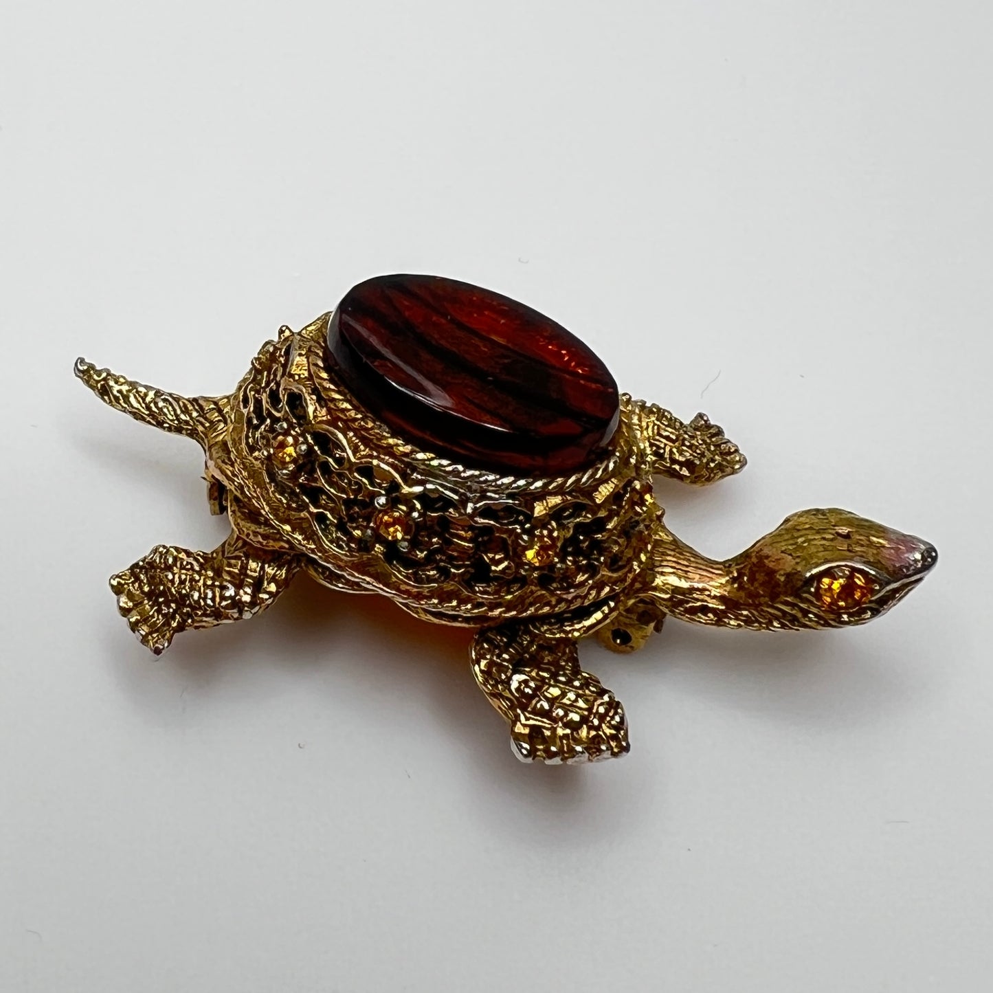 Close-up of turtle brooch with yellow rhinestones and detailed gold filigree