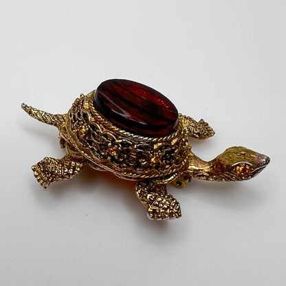 Close-up of turtle brooch with yellow rhinestones and detailed gold filigree