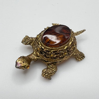Close-up of turtle brooch with yellow rhinestones and detailed gold filigree