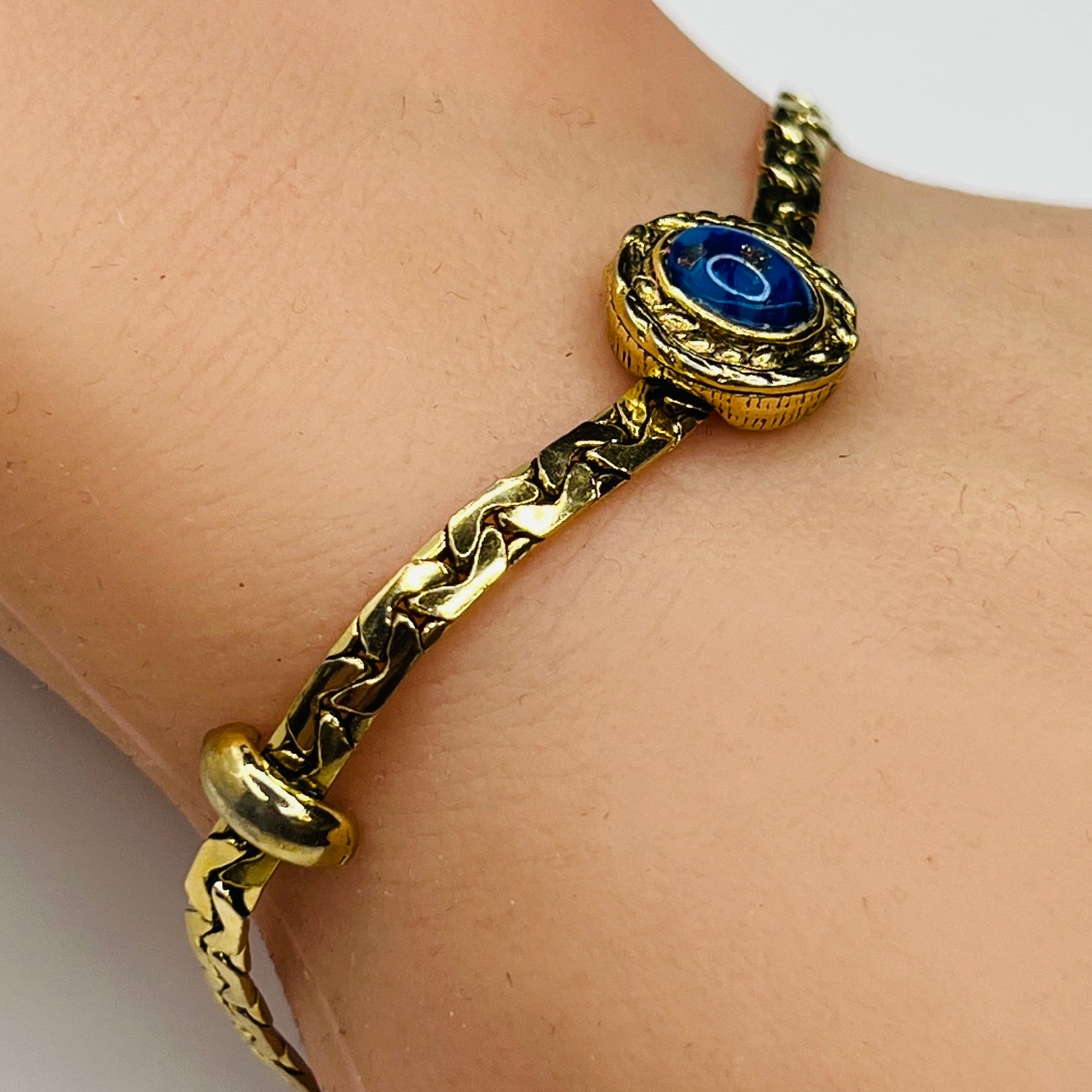 Goldette bracelet with lapis blue cabochon on wrist