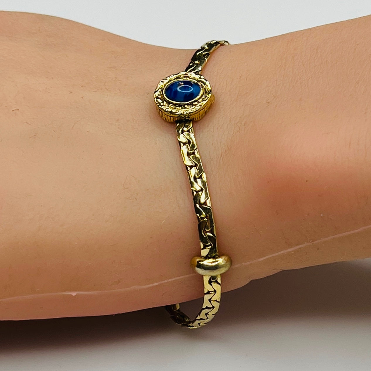 Goldette bracelet with lapis blue cabochon on wrist