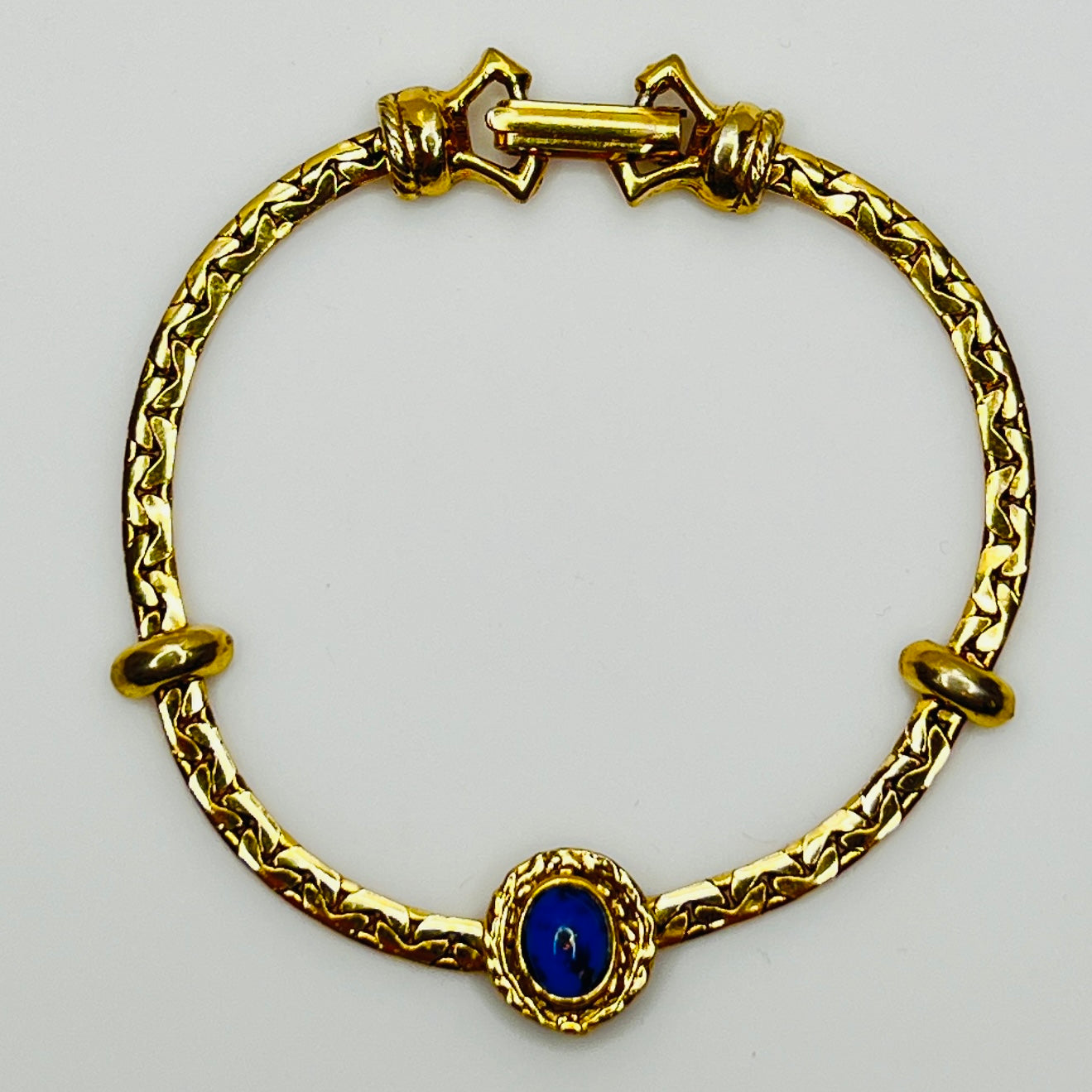 Full view of gold-tone bracelet with fold-over clasp