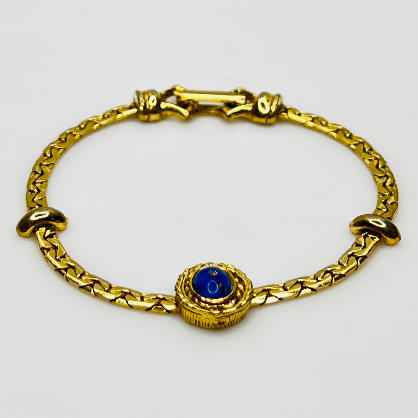 Full view of gold-tone bracelet with fold-over clasp