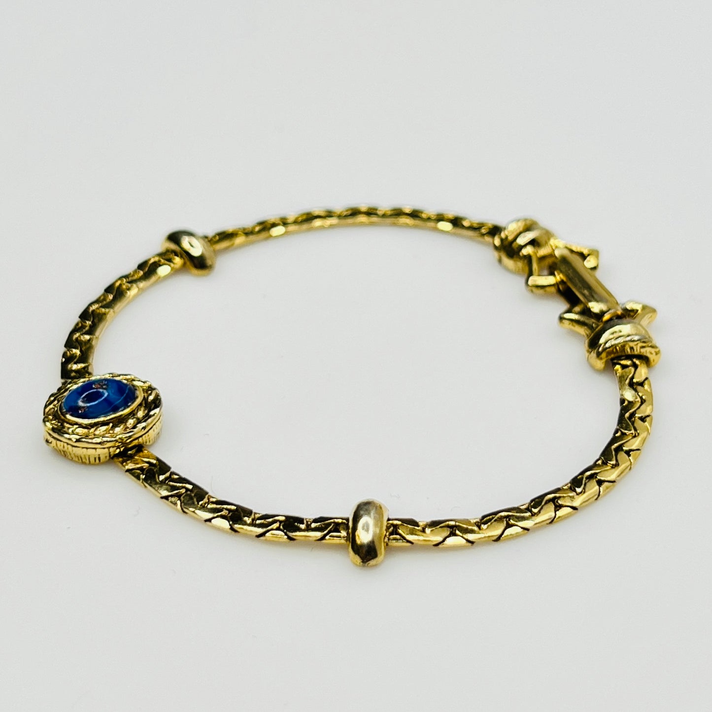 Full view of gold-tone bracelet with fold-over clasp