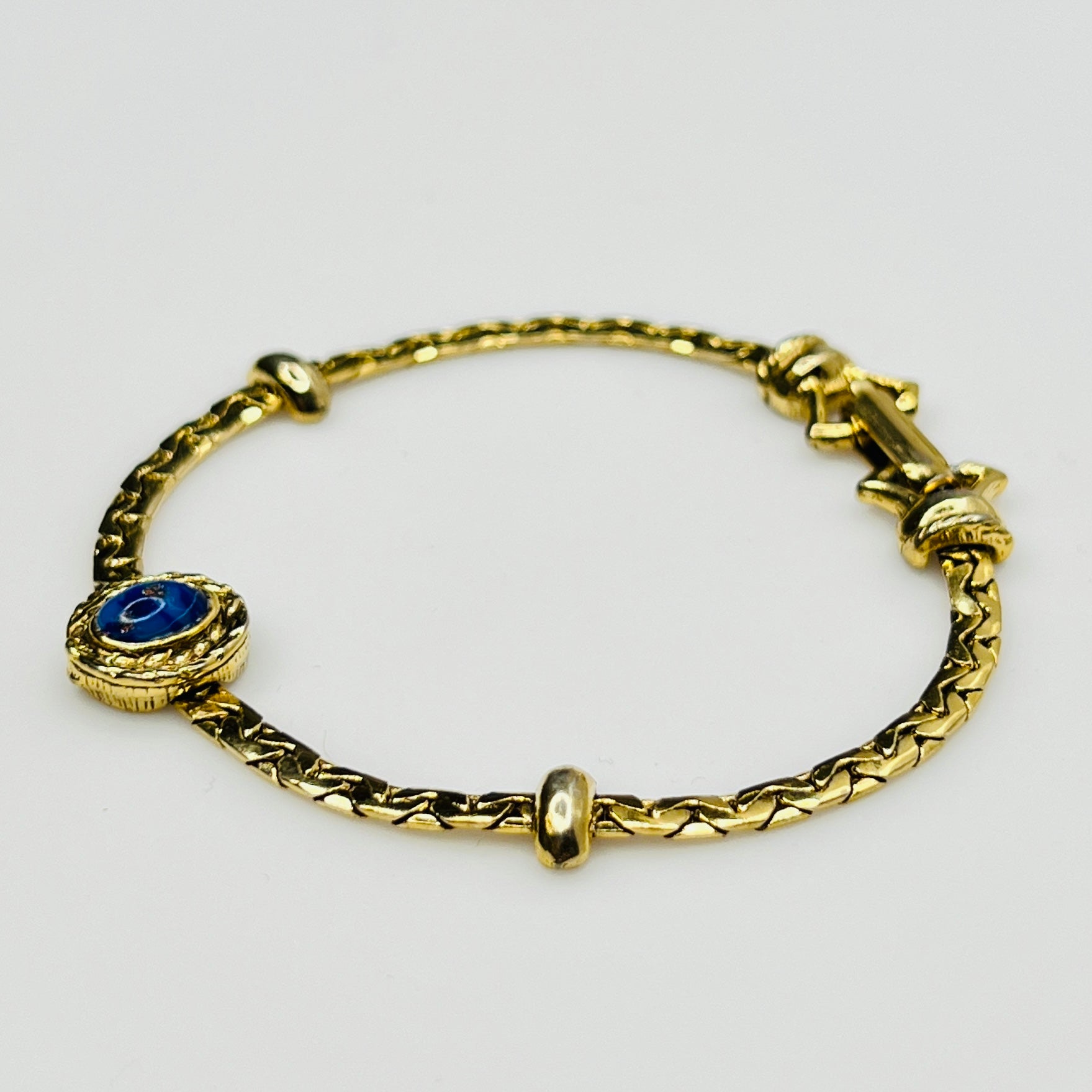 Full view of gold-tone bracelet with fold-over clasp