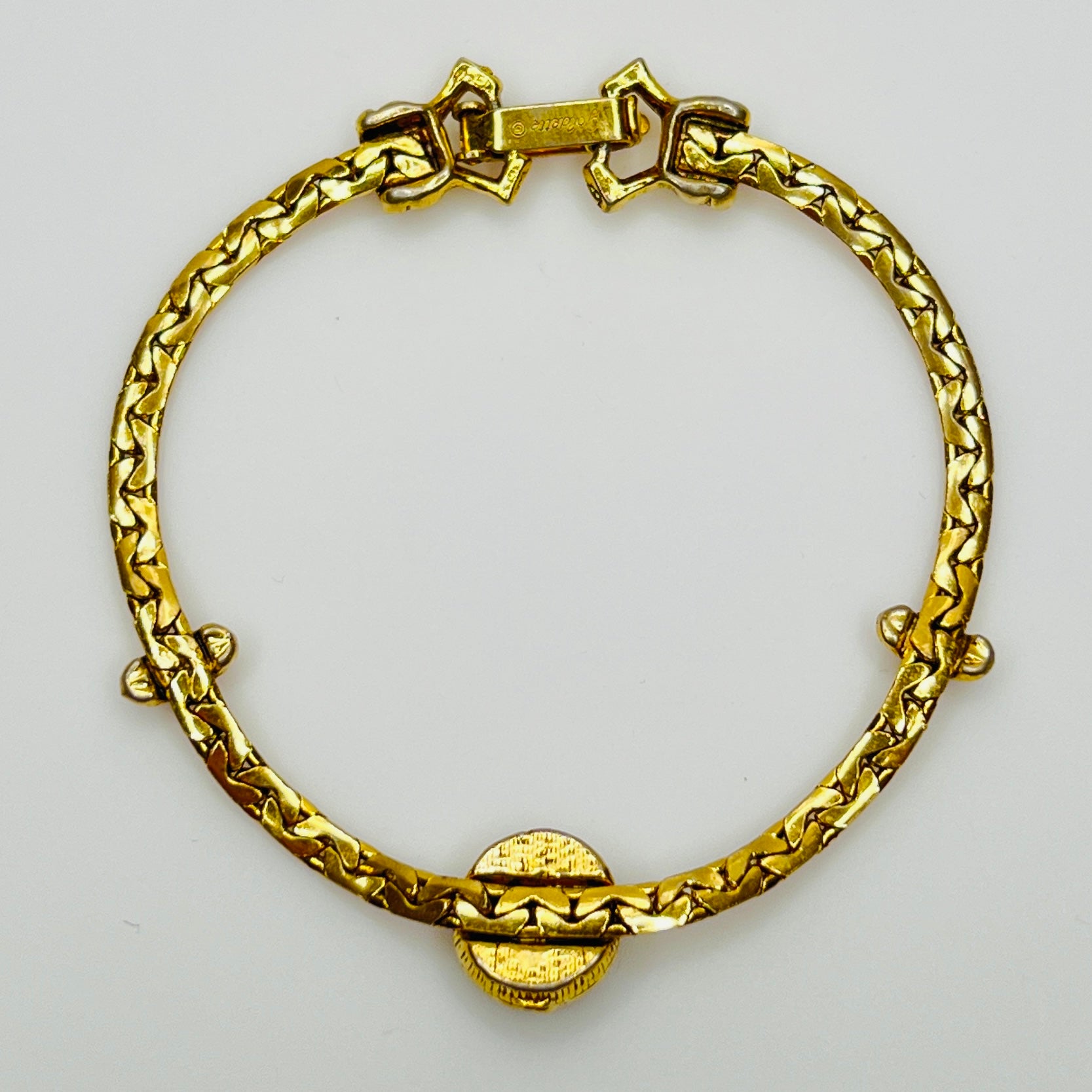 Full back view of gold-tone bracelet with fold-over clasp