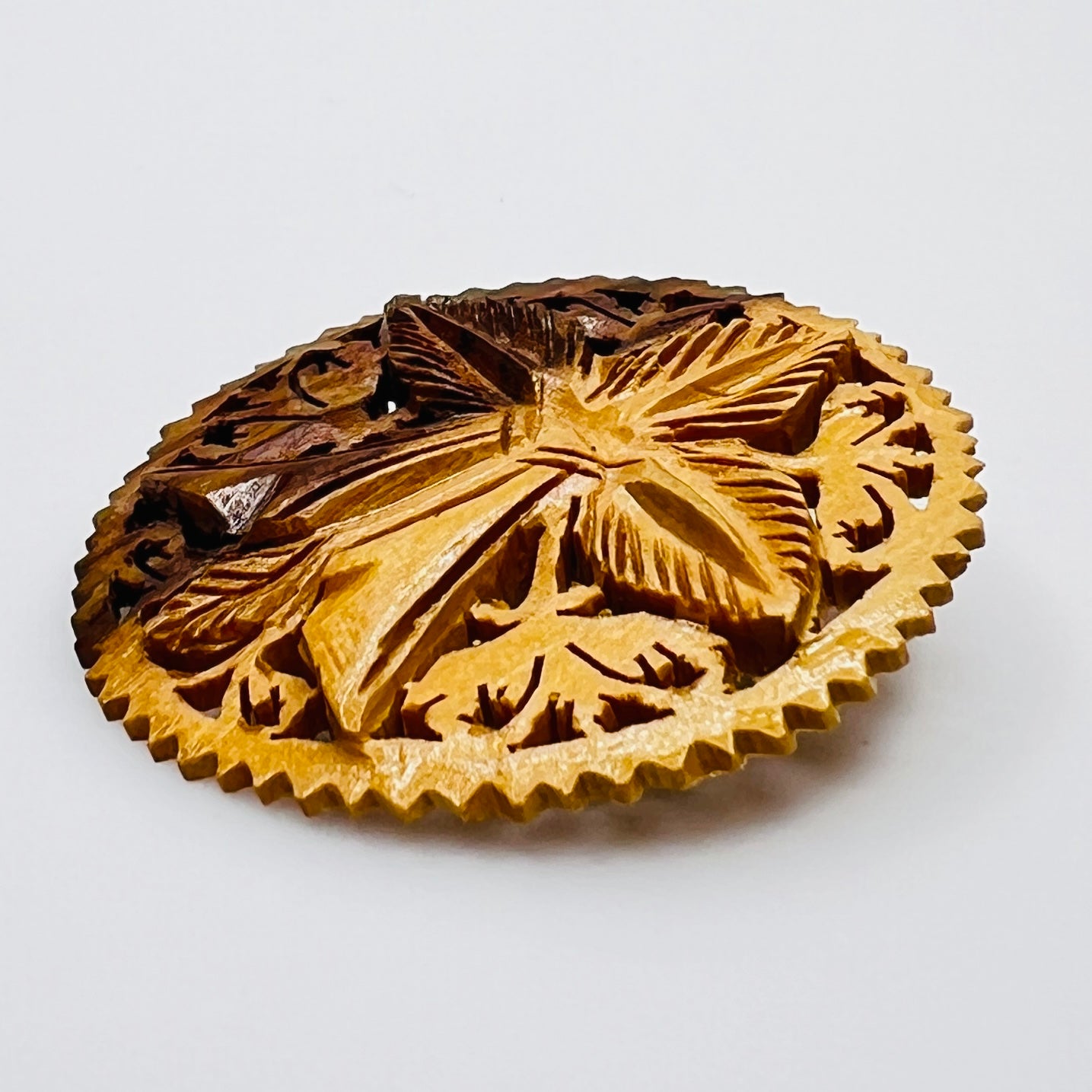 Carved wooden floral pin in honey brown tones