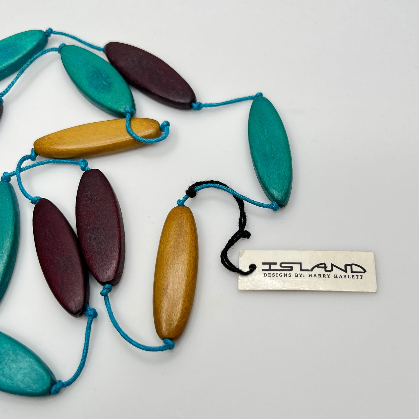 Necklace with wooden and turquoise beads on a white background, featuring the 'Island' brand.