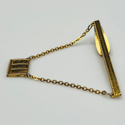 Vintage brass tie bar with "SEL" monogram and chain guard, 1950s