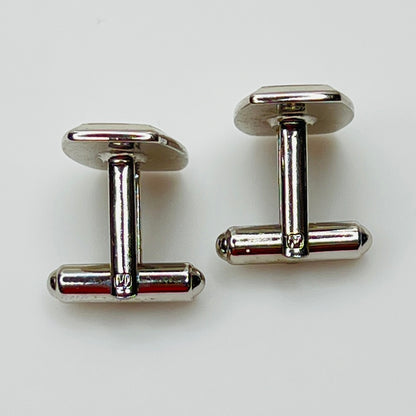 Pair of silver cufflinks on a white background