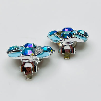Close-up of round rhinestone earrings with blue enamel petals