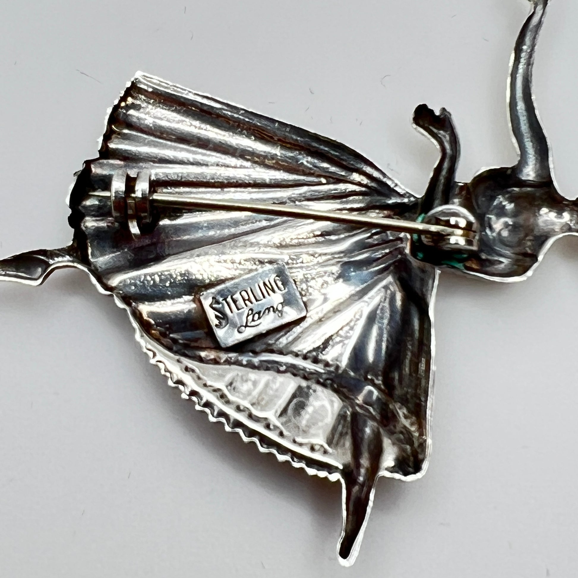 Back view showing “STERLING Lang” maker’s mark and pin clasp