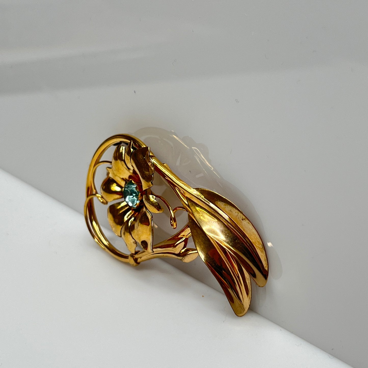 Vintage 12K gold-filled flower brooch with blue rhinestone center