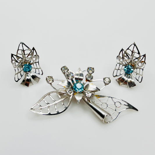 Silver-tone brooch and earrings set with blue rhinestones in Mid-Century starburst design