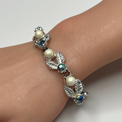 Silver leaf link bracelet with faux pearls and blue rhinestones worn on wrist