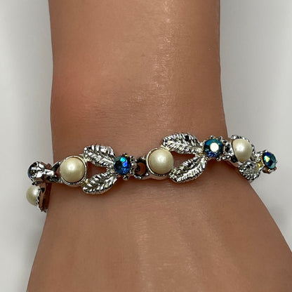Silver leaf link bracelet with faux pearls and blue rhinestones worn on wrist