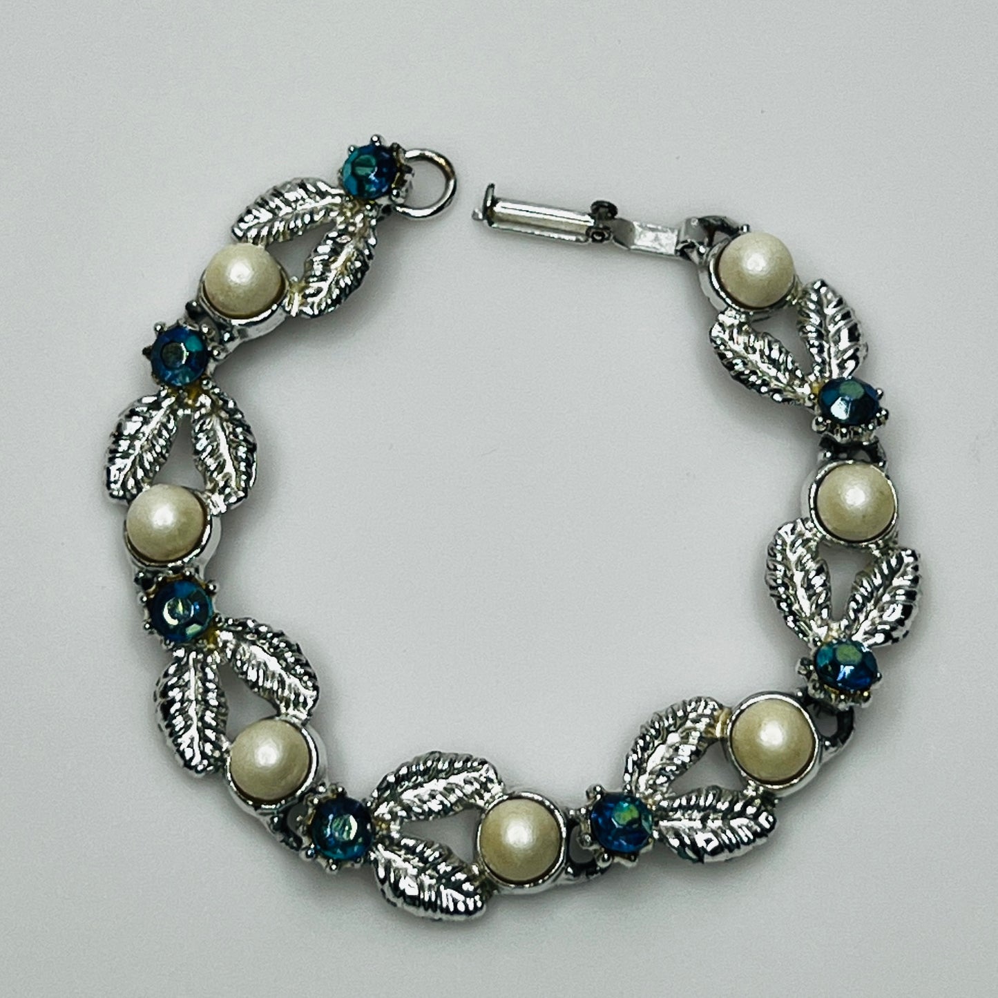 Close-up of vintage silver bracelet with aurora borealis stones and pearl details