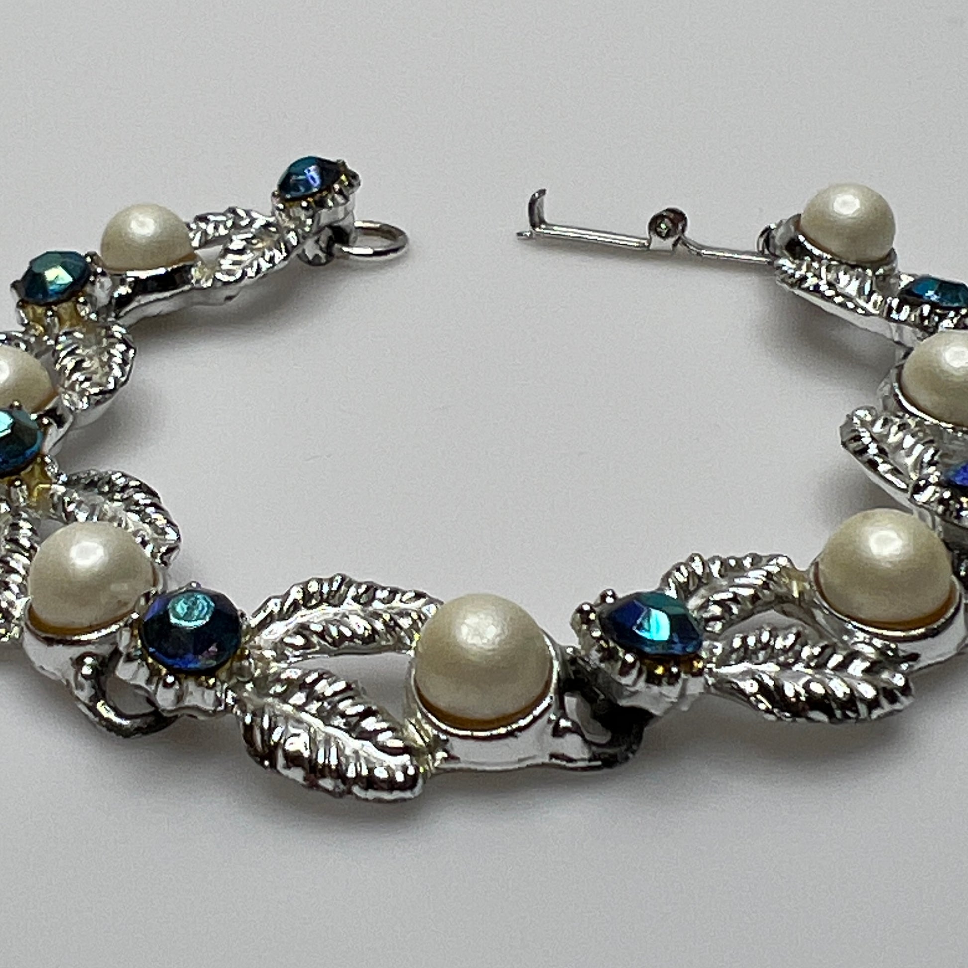 Close-up of vintage silver bracelet with aurora borealis stones and pearl details