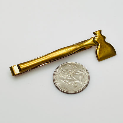 Close-up of novelty axe-shaped tie clip, mid-century brass finish