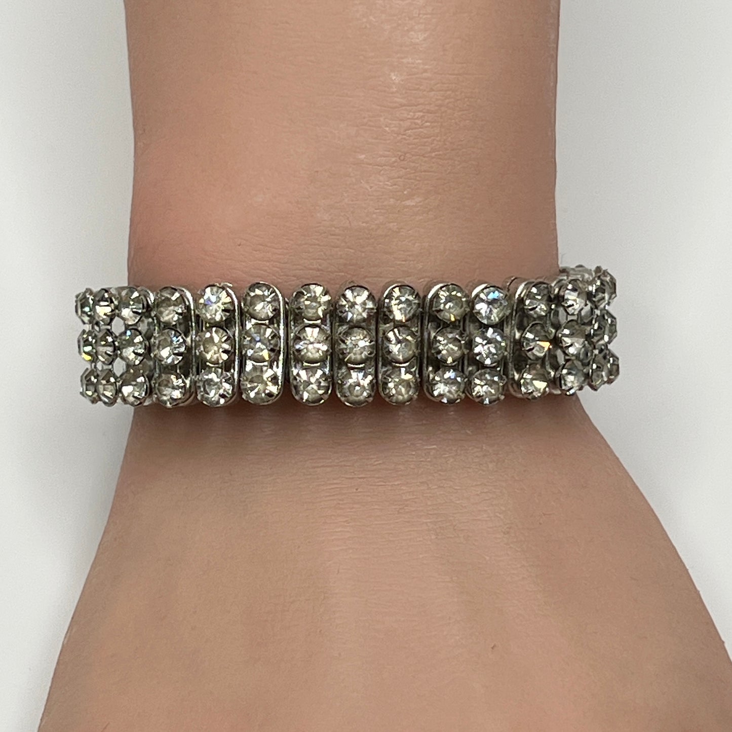 Close-up of vintage silver-tone accordion rhinestone bracelet on wrist