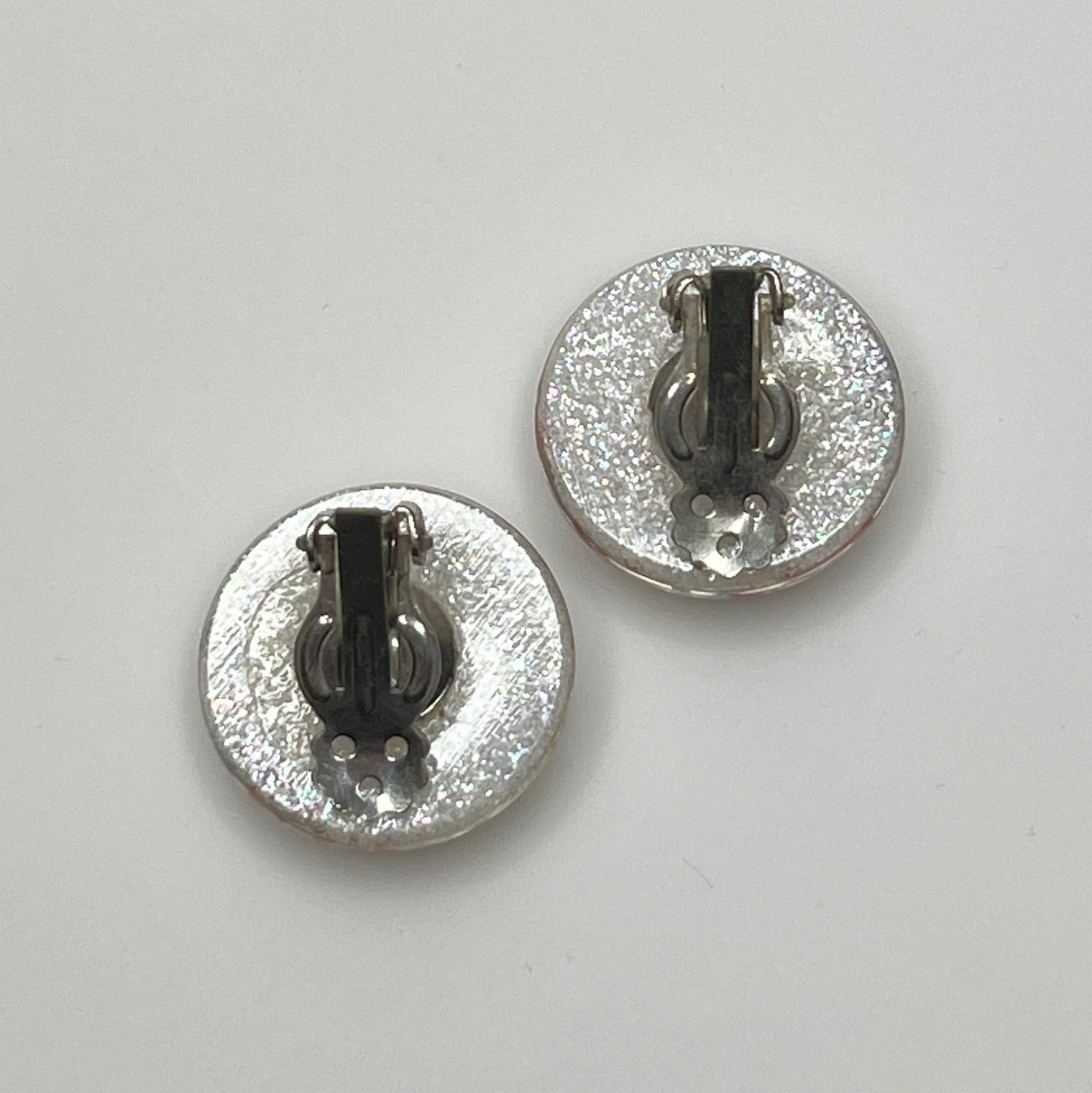 Mid-century plastic earrings with suspended confetti sparkle