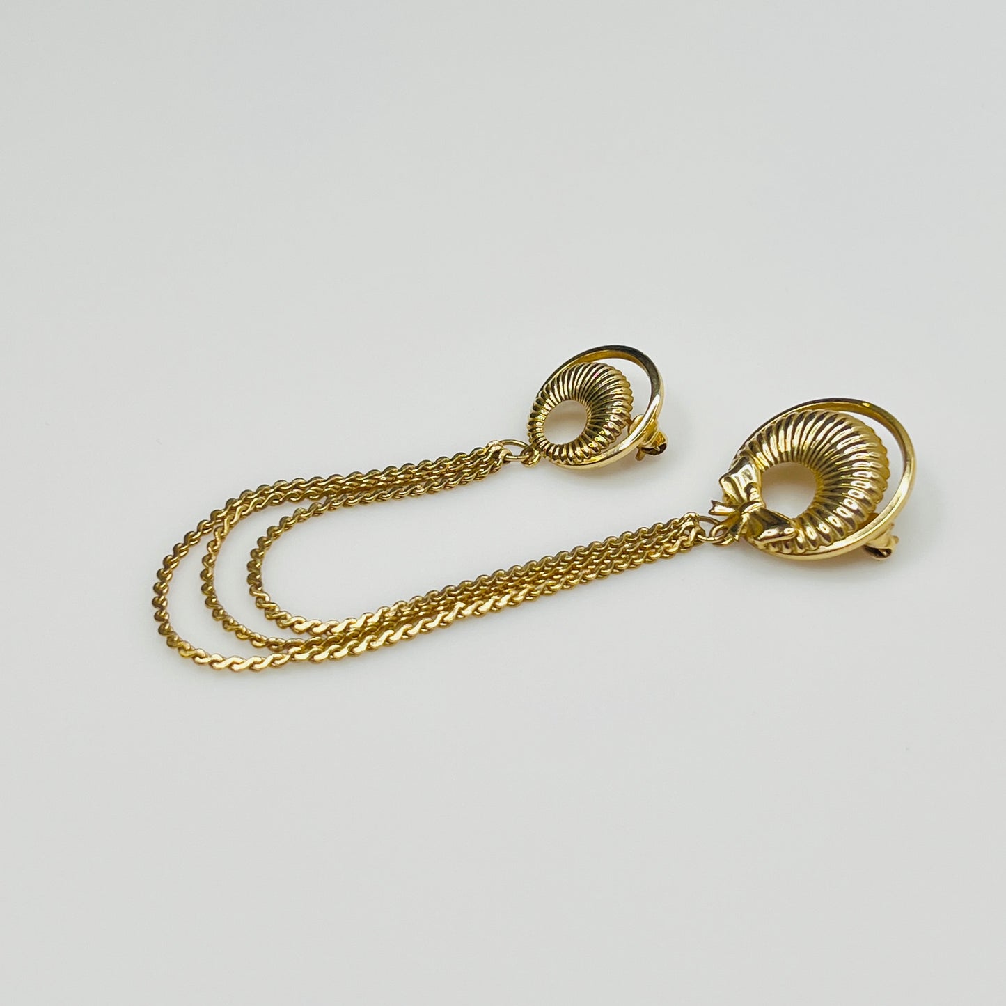 Mid-century gold chatelaine brooch with double wreaths, bow detail, and triple chain drape