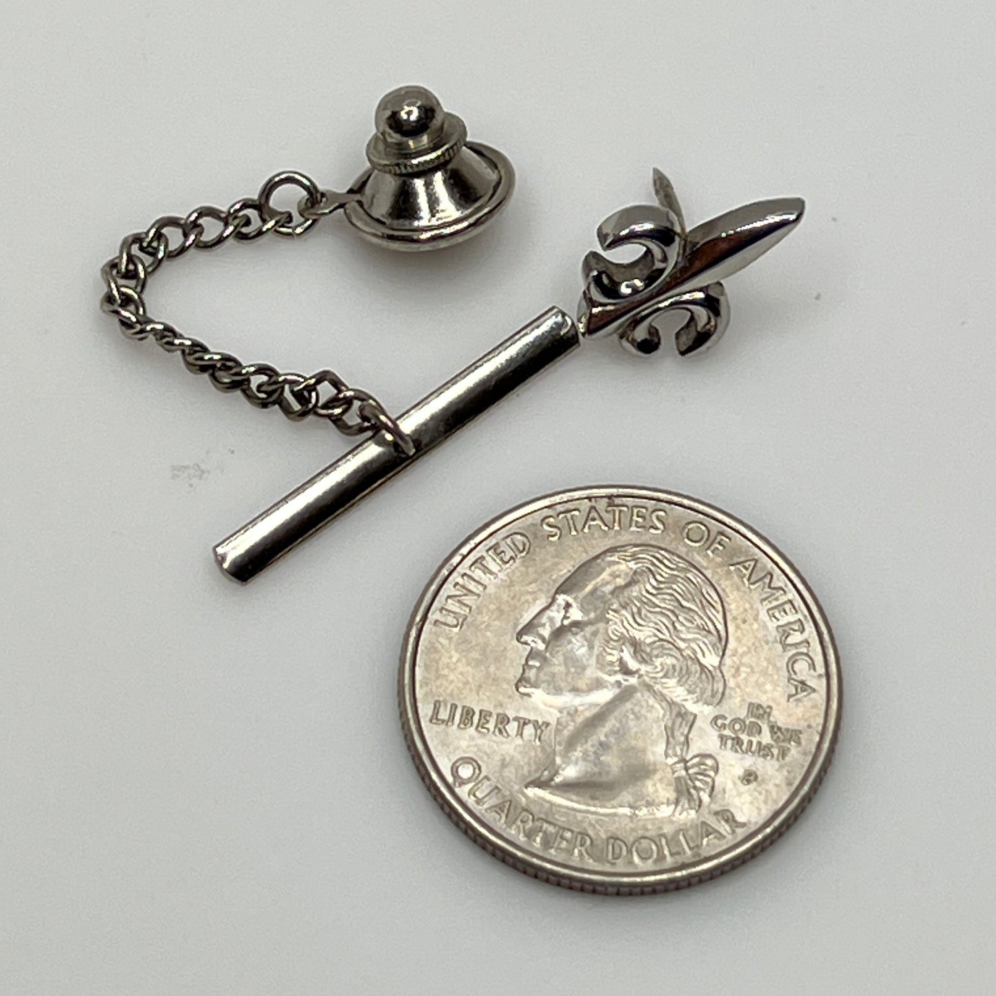 Vintage silver fleur-de-lis tie tack with chain and clutch backing.