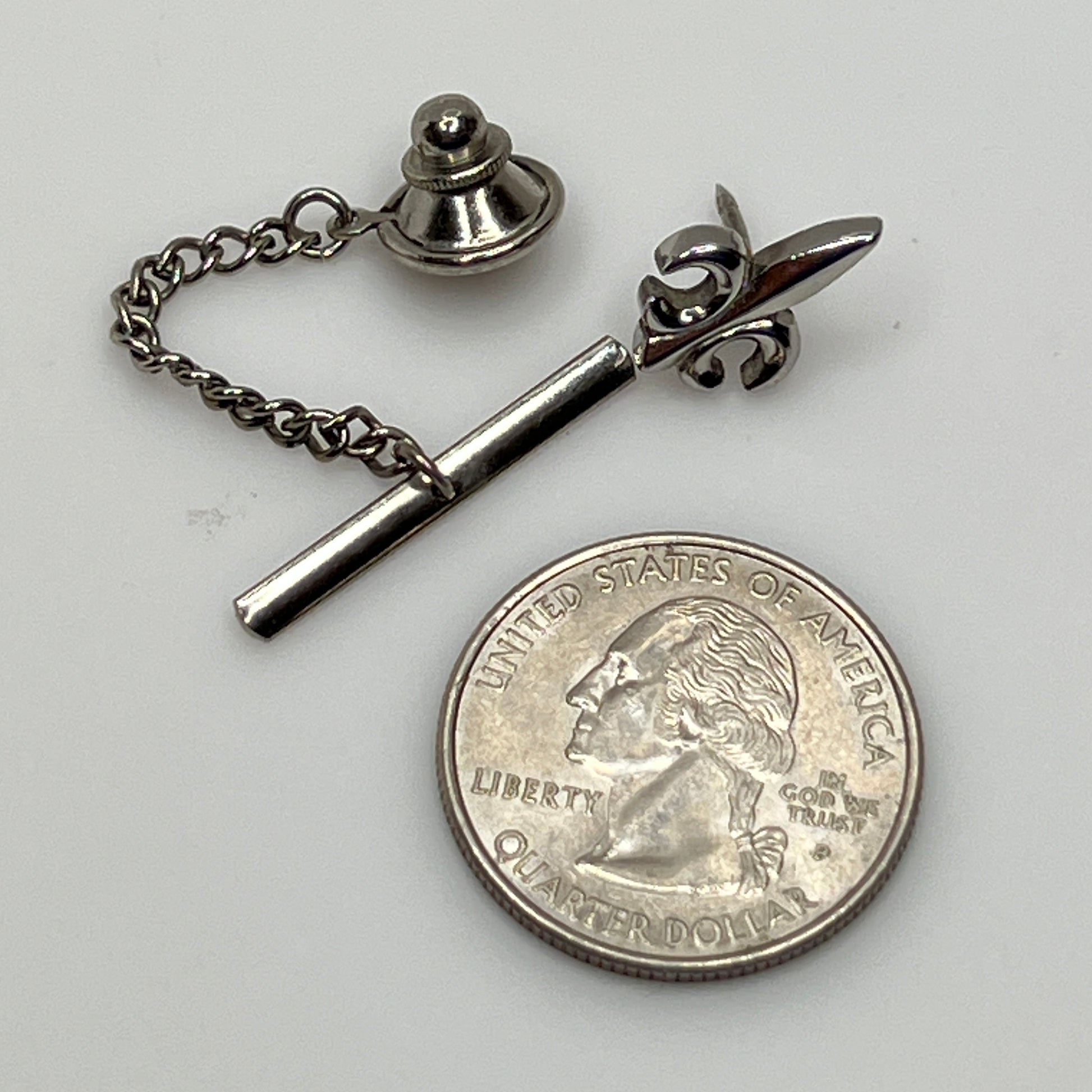 Vintage silver fleur-de-lis tie tack with chain and clutch backing.