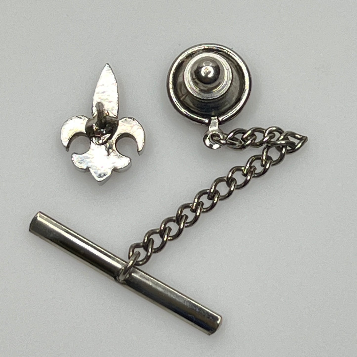 Vintage silver fleur-de-lis tie tack with chain and clutch backing.