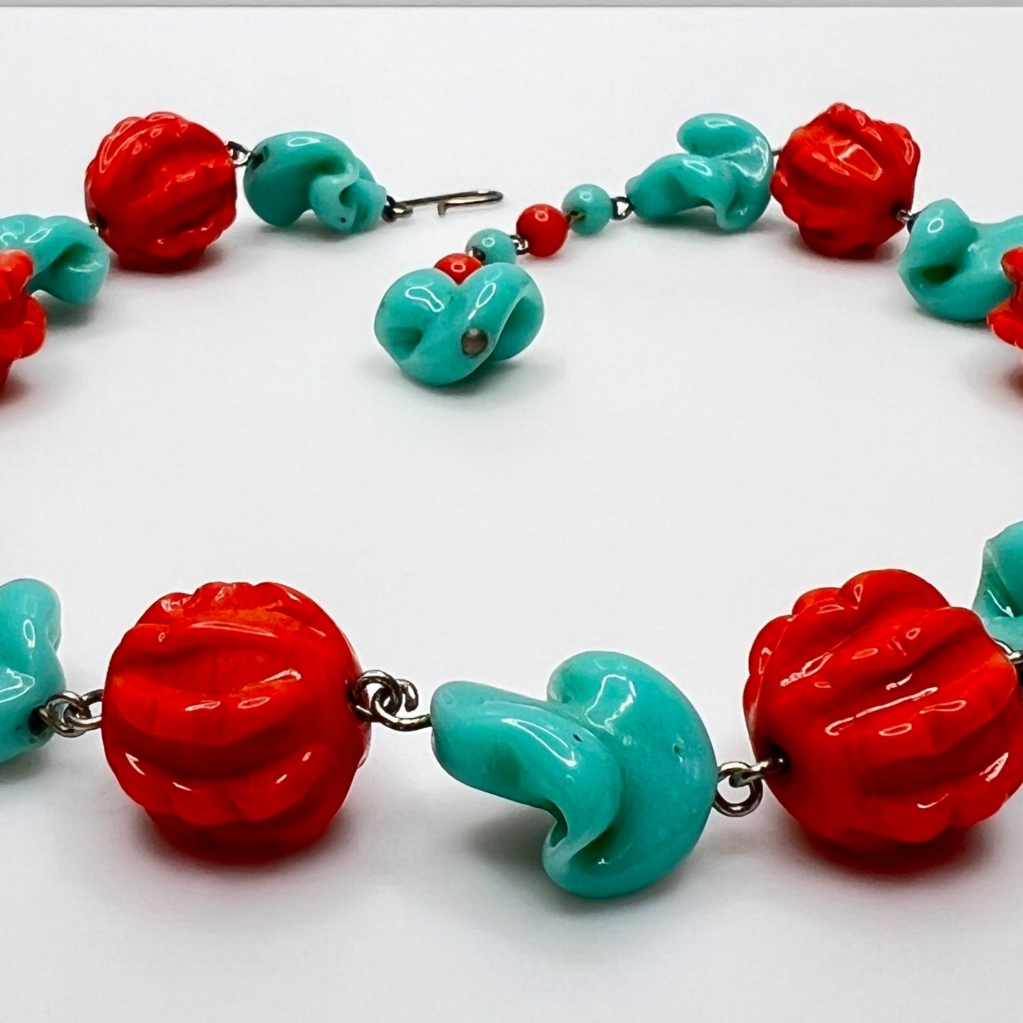 Close-up of sculpted glass beads with hook clasp and extender