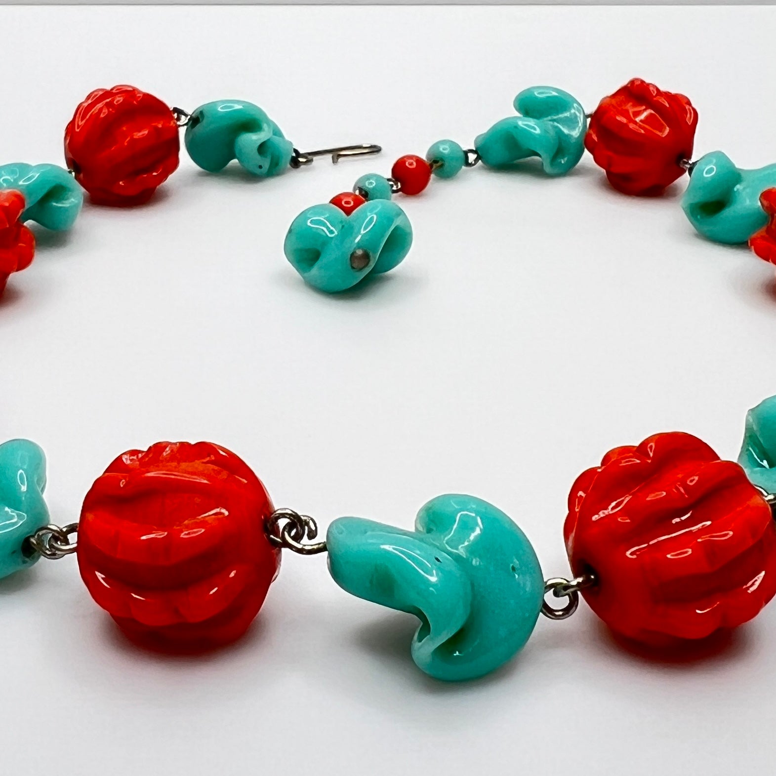 Close-up of sculpted glass beads with hook clasp and extender