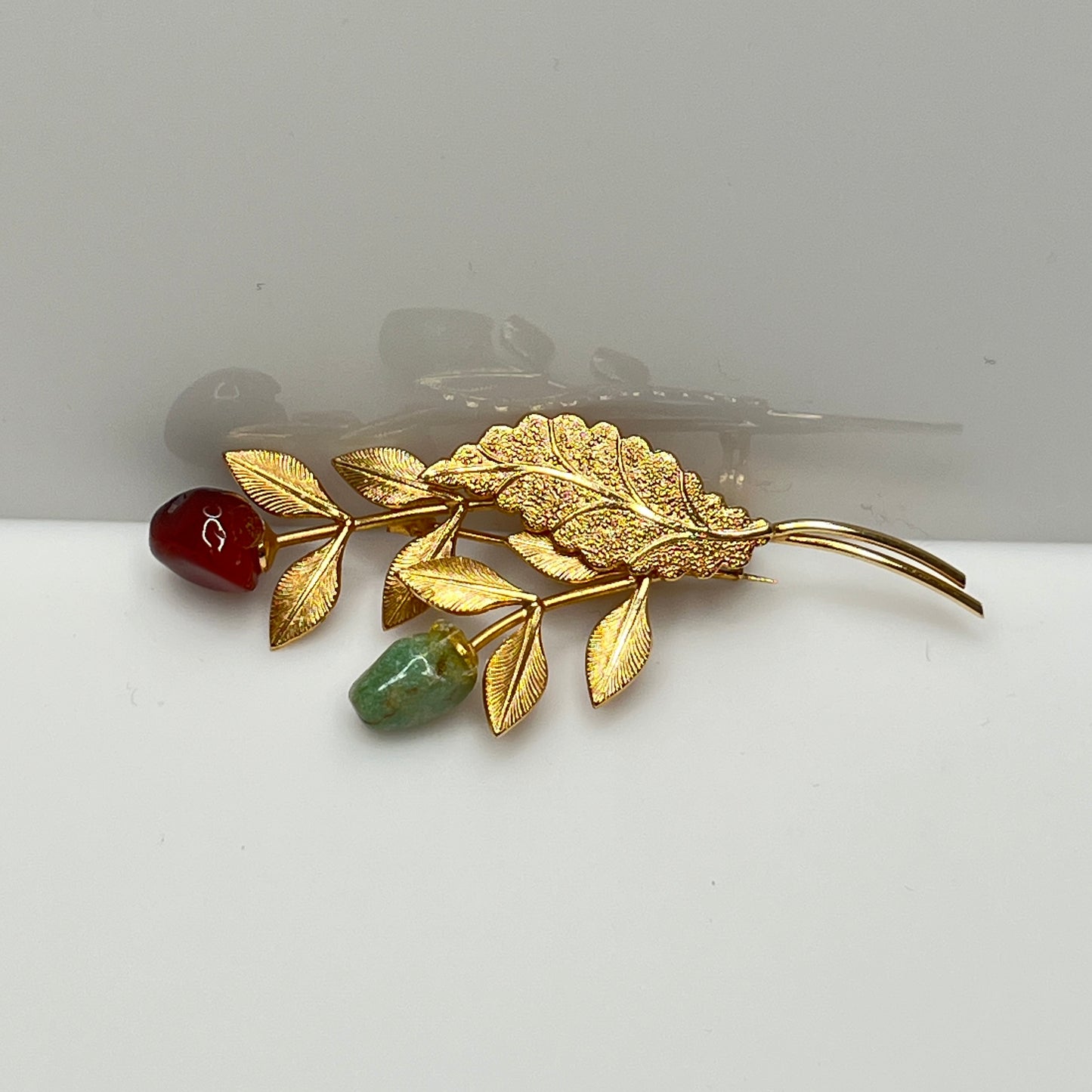 Vintage gold-tone brooch with red and green jade rose buds on long stem