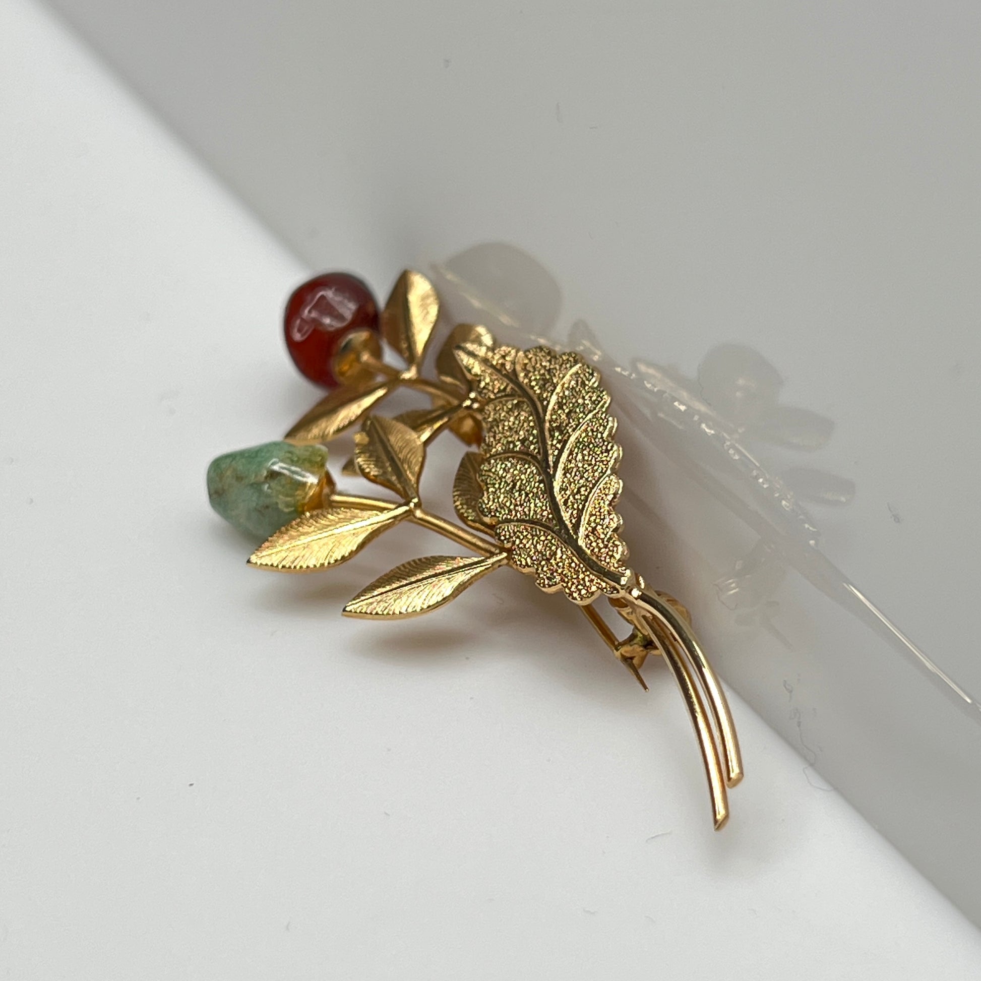 Vintage gold-tone brooch with red and green jade rose buds on long stem