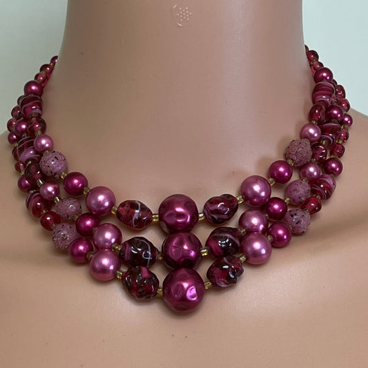 Triple-strand fuchsia bead necklace with faux pearls and glass beads, on mannequin