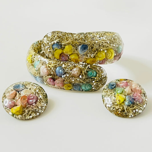 Vintage hinged bracelet and earrings with colorful shells suspended in clear lucite