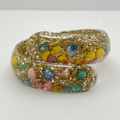 Vintage hinged bracelet with colorful shells suspended in clear lucite