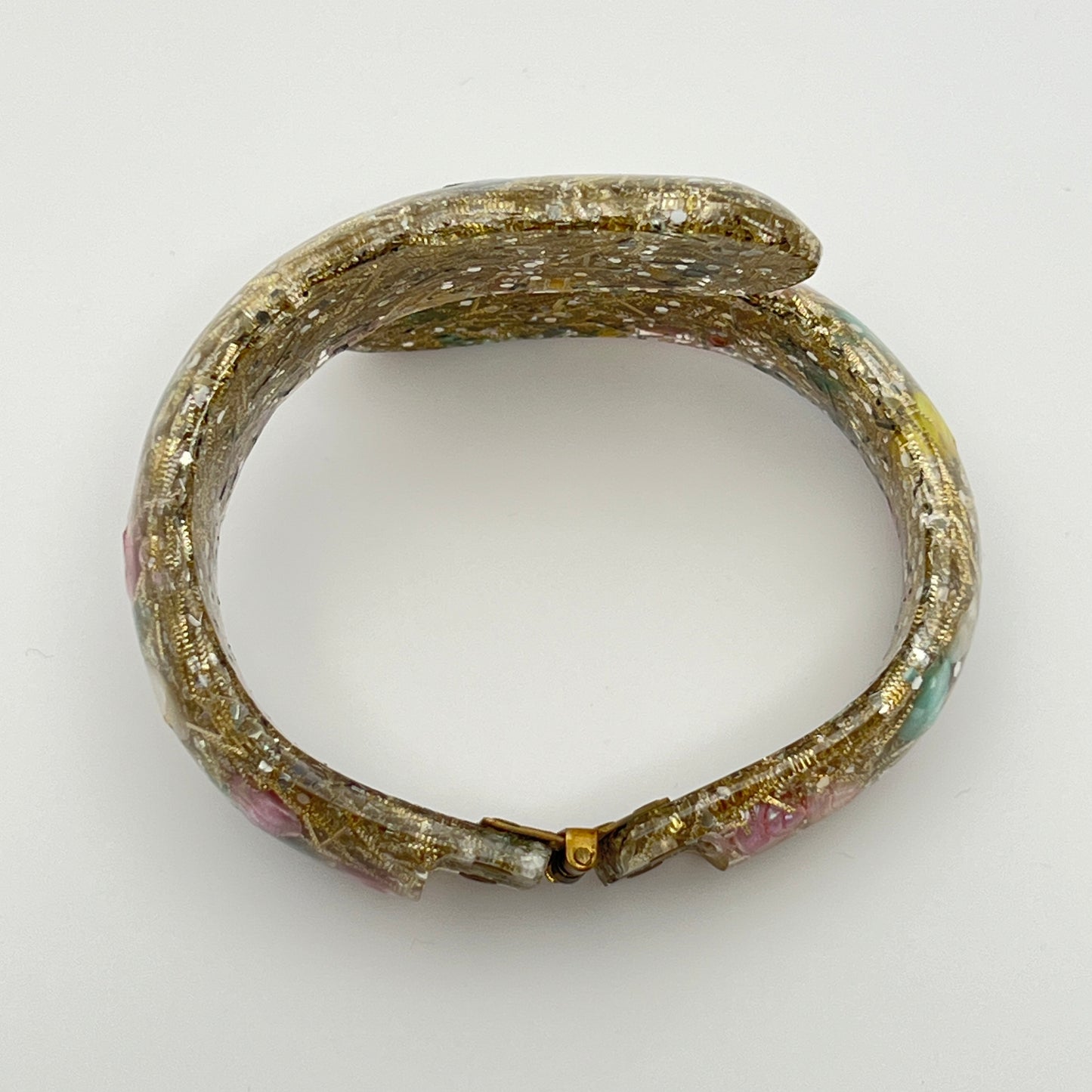 Vintage hinged bracelet with colorful shells suspended in clear lucite