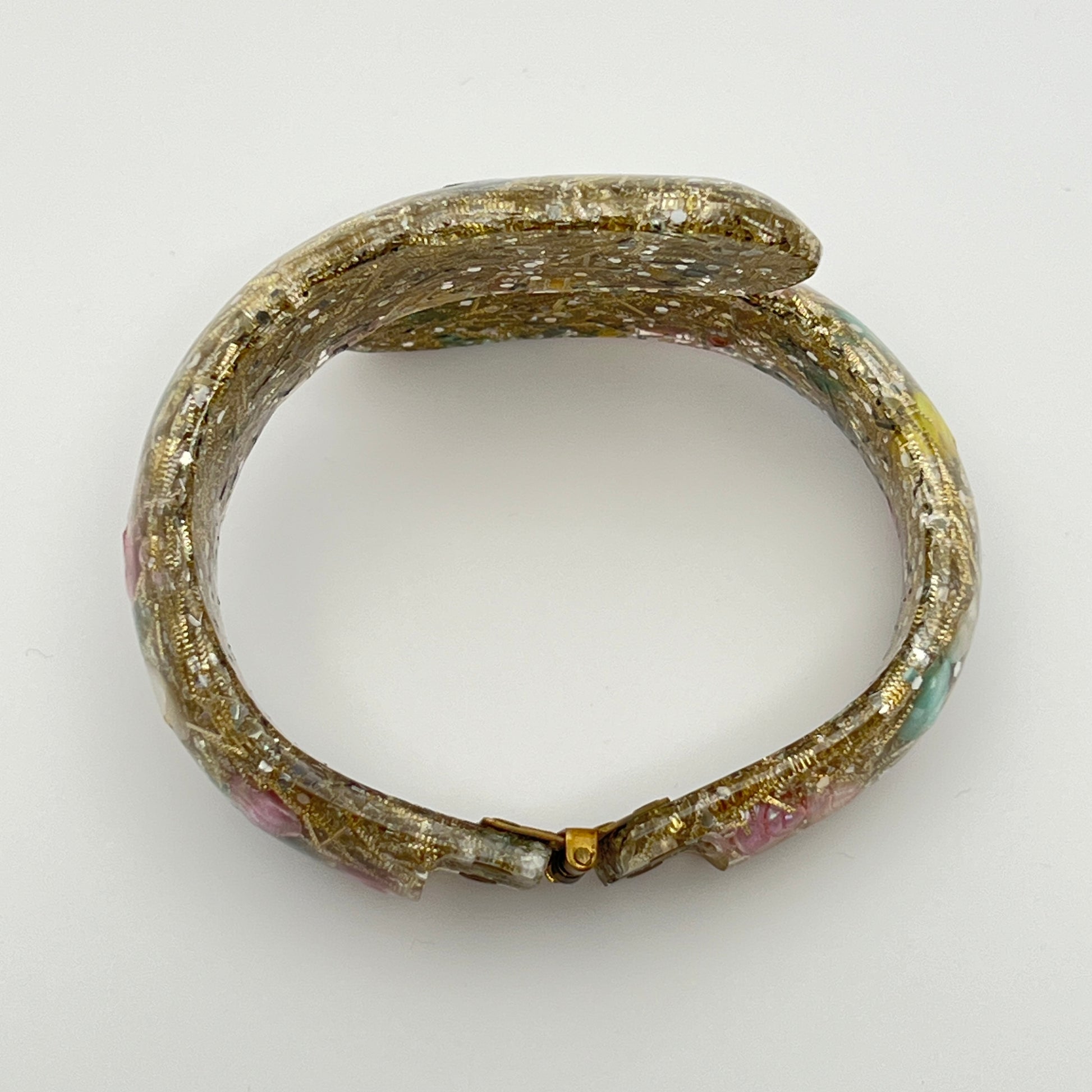 Vintage hinged bracelet with colorful shells suspended in clear lucite