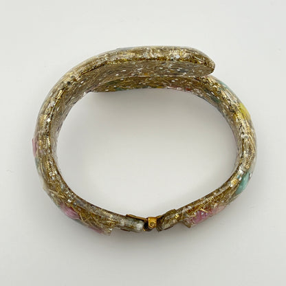 Vintage hinged bracelet with colorful shells suspended in clear lucite