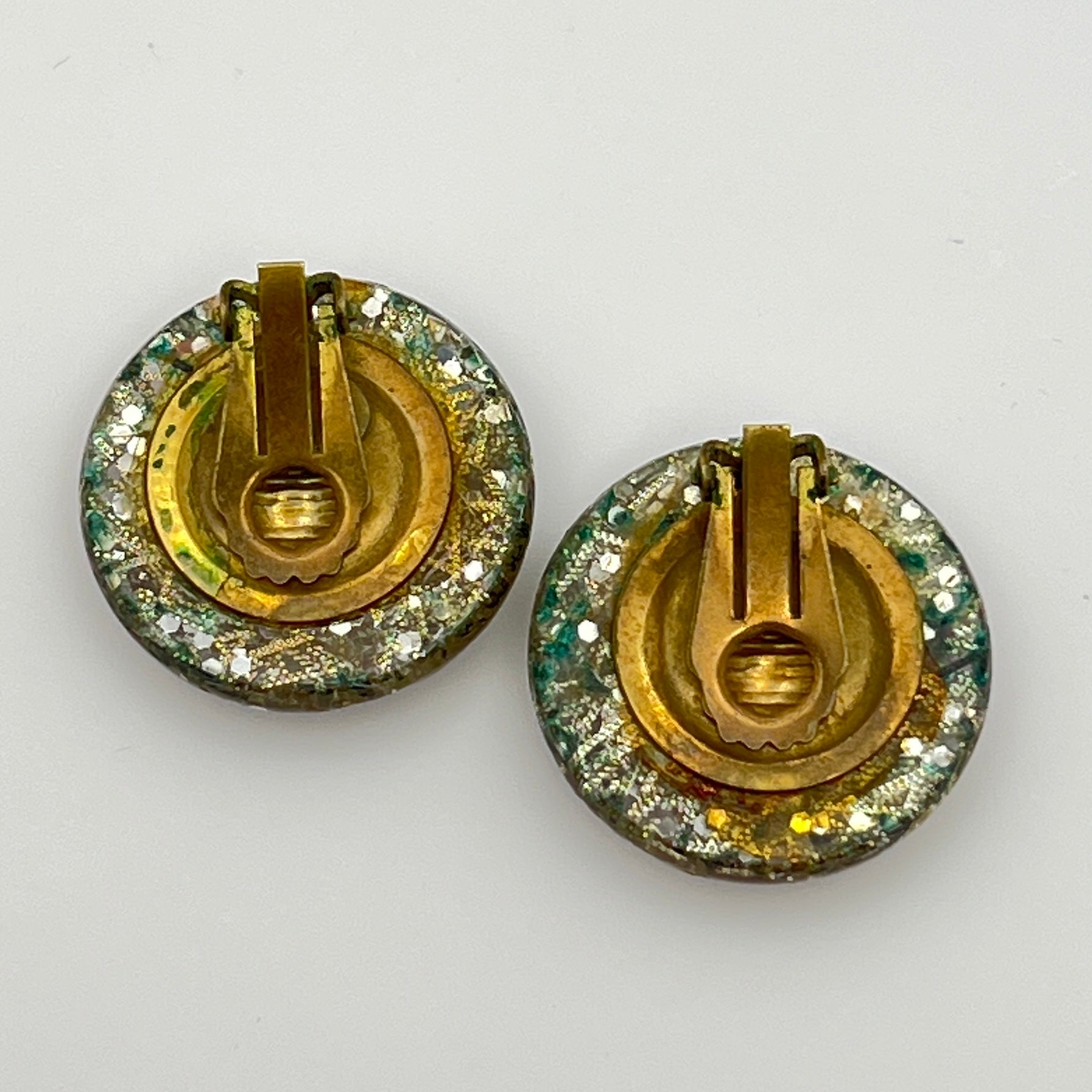 Close-up of lucite earrings with multicolor seashells and gold sparkle